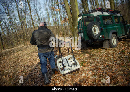 Walbrzych, Polen. 17 Mär, 2019. Piotr Koper, Auftragnehmer und Treasure Hunter, Spaziergänge durch den Wald mit einem Metalldetektor. Der Geschäftsmann ist hauptsächlich für die Suche nach einem versteckten Tunnel System und die so genannte "Gold" aus der NS-Zeit in der Stadt von Walbrzych in Polen verantwortlich. (Dpa' Polnischen gold Zug hunter Begegnungen unerwartete Schatz 'Credit): Gregor Fischer/dpa/Alamy leben Nachrichten Stockfoto