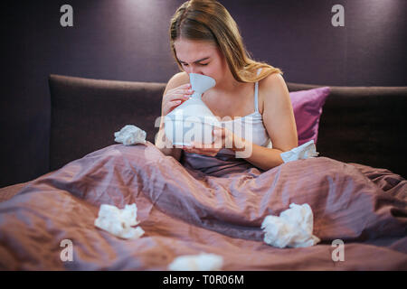 Bild der jungen Frau mit Inhalator für Heilung. Sie Luft inhaliert, mit verschiedenen Leckereien. Frau sitzt auf dem Bett allein. Es gibt viele auf weißem verwendet Stockfoto