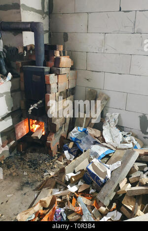 Der Holzofen brennt mit offenen Türen in der Verletzung der stellt eine Gefahr für das Gebäude durch den Brand ein Brand 2019 Stockfoto