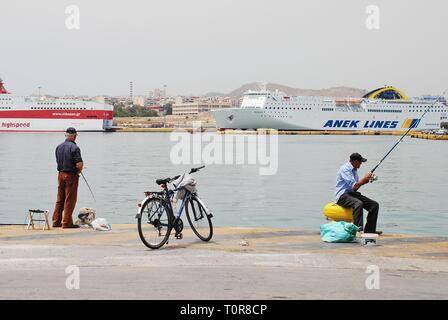 Zwei männliche angler angeln am Hafen von Piräus in Athen, Griechenland, 11. Mai 2016. Piräus ist der größte Hafen Europas. Stockfoto