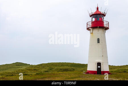 Leuchtturm List-West innerhalb einer Dünenlandschaft mit Gras und Sand. Detailansicht an einem klaren Tag. In List auf Sylt, Schleswig-Holstein, Deutschland. Stockfoto