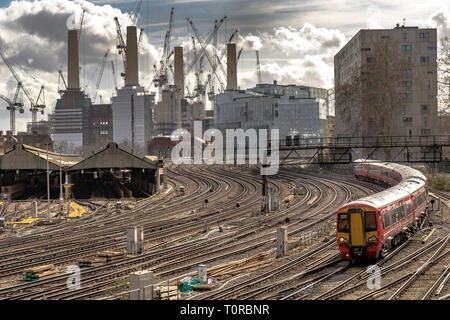 Der Gatwick Express nähert sich der Ebury Bridge auf dem letzten Weg zum Bahnhof Victoria, mit dem Battersea Power Station in der Ferne, London, Großbritannien Stockfoto