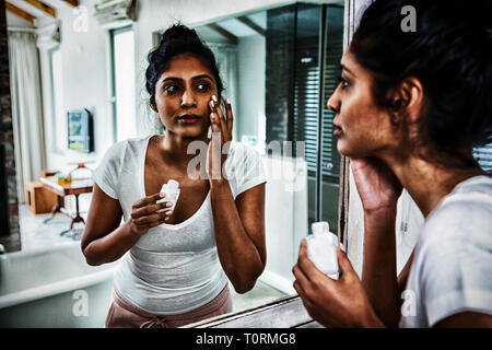 Junge Frau eincremen Stockfoto