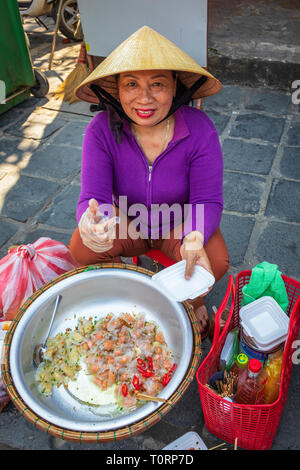 Frau verkaufen Reis Paper von Fisch und Huhn von einer Straße Küche, Hoi An, Vietnam, Asien Stockfoto