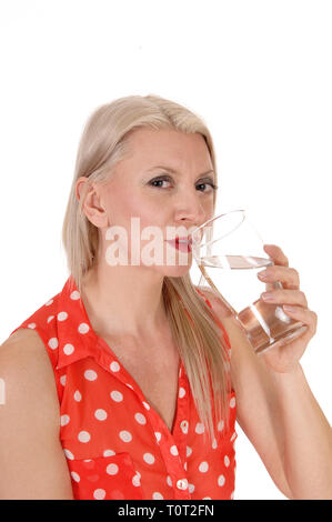 Eine Nahaufnahme Bild einer schönen Frau in einem roten Bluse mit einem Glas Wasser und trinken, auf weißem Hintergrund Stockfoto