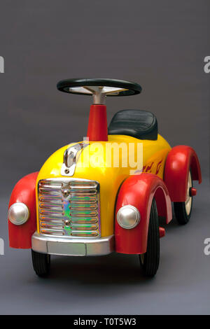 altes Spielzeugauto auf grauem Hintergrund Stockfoto