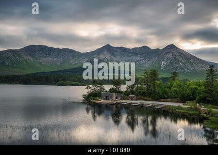 Lough Inagh in Irland mit einer Kabine und Boote am See Stockfoto