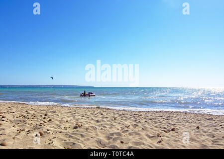 PALMA DE MALLORCA, SPANIEN - 17. MÄRZ 2019: Sandstrand und Kitesurfer mit Ozean Horizont an einem sonnigen und windigen Tag am 17. März 2019 in Palma de Mallo Stockfoto