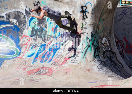 Junger Mann Skateboarder im Riverside River Yard Skateboard Bowl, tolle Herbst, Montana, USA Stockfoto