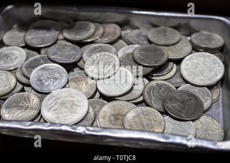 Haufen Metall Münzen verschiedener Konfessionen und verschiedenen Ländern in Metallbox Stockfoto