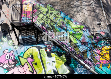 Eine große Anzahl von bunten Wandmalereien, die zu einer ungewöhnlichen Touristenattraktion in einer Gegend geworden sind, die als Graffiti Alley in Toronto Ontario Canada bekannt ist Stockfoto