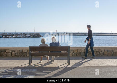 PALMA DE MALLORCA, SPANIEN - 17. März, 2019: Ältere Paar genießen die kleine Bucht Meerblick auf einer Bank an der Promenade an einem sonnigen Tag am 17. März 2019 in P Stockfoto