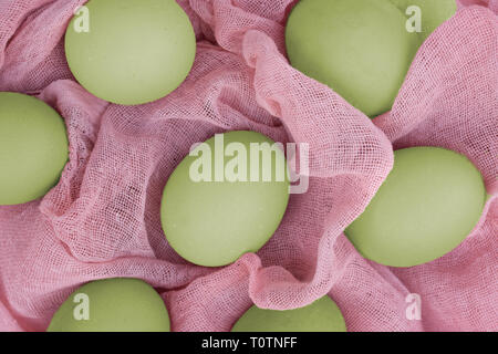 Grüne Ostereier auf rosa Tuch. Stockfoto