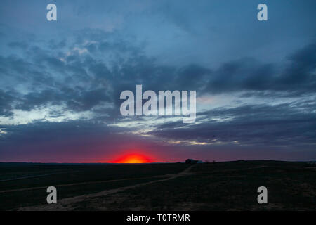 Sonnenaufgang über dem Gegentala Grasland nördlich von Hohhot, Innere Mongolei, China. Ein einsames Haus mit einer Jurte (Ger) auf den weiten Ebenen. Stockfoto