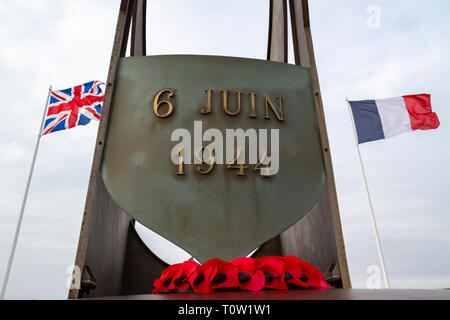 Ein Mohn Kranz unter der Kieffer Flamme Denkmal am Sword Beach, Cabourg, Normandie, Frankreich. Stockfoto