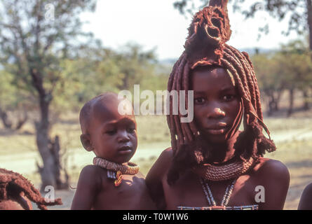 Junge Himba Mutter mit ihrem Baby in ihren Armen Stockfoto