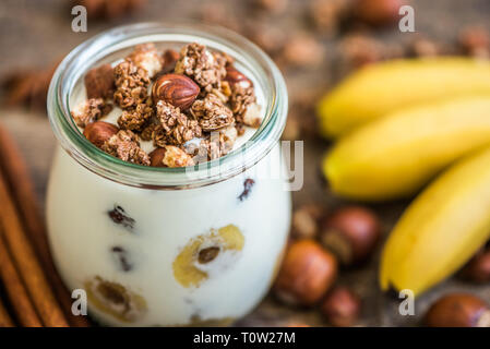 Mit Joghurt mit Müsli, Bananen und Nüsse Stockfoto