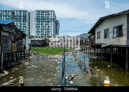 Einem traditionellen Stelzenhaus wasser Siedlung sitzt vor der modernen Entwicklung in Kota Kinabalu, Sabah, Borneo, Malaysia. Stockfoto