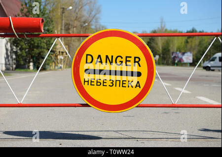 Zeichen Gefahr und während der Fahrt durch ein Hindernis auf der Kreuzung Dytiatky, wo Tschernobyl Sperrzone beginnt. 20. April 2018. Dytiatky, Ukraine Stockfoto