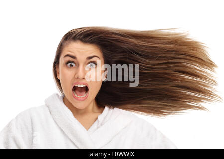 Schockiert Frau in einen Bademantel mit ihrem Haar weht an der Seite auf weißem Hintergrund Stockfoto