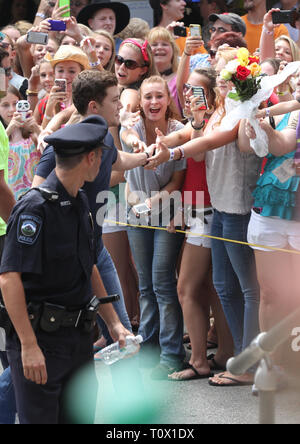 Begeisterten Fans werden angezeigt zu erreichen, die Sänger Scotty McCreery, während er auf der Bühne seinen "Live"-Konzert zu beginnen. Stockfoto