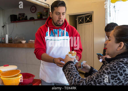 Junge Mexikanerin kaufen street Tacos aus einem Café in Santiago de Querétaro, Mexiko Stockfoto