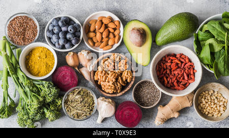 Gesunde, saubere Lebensmittel - Gemüse, Früchte, Nüsse, superfoods auf grauem Hintergrund. Gesunde Ernährung Konzept. Stockfoto