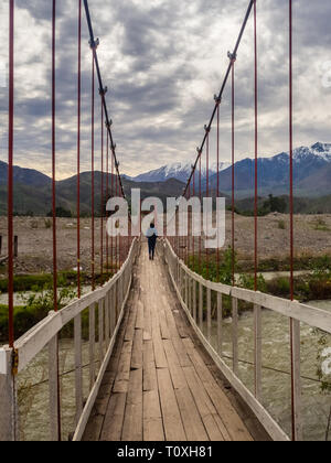 Landschaft in der Nähe von Vicuña in Chile mit einem Mädchen Überquerung einer Hängebrücke. Sicht auf die Berge im Elqui-tal Stockfoto