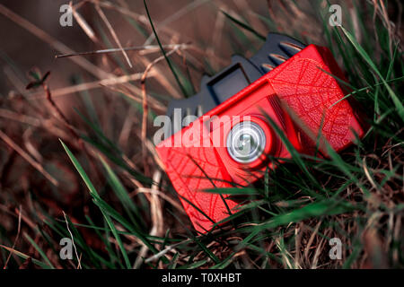 Kamera aus rotem Kunststoff Spielzeug in Gras Hintergrundbild fine art Stockfoto