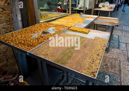 In der Nähe der Stände mit süßen Früchten und Gebäck zum Verkauf in der Nähe von einigen Street Food cafe in Jerusalem ausgesetzt. Jerusalem, Israel, 24. Oktober 2018 Stockfoto