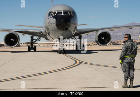 Die kolumbianische Luftwaffe Multi-Mission Transport Tanker Jupiter 767 Crew Chief kommuniziert mit der Aircraft Maintenance Crew nach Regie der Flugkapitän der Flugzeuge während Red Flag 19-2 zu Park an der Nellis Air Force Base, Nev, 14. März 2019. Dies ist zum dritten Mal die kolumbianische Luftwaffe in eine rote Fahne Übung teilnehmen. Zuvor beteiligte sich 2012 und 2018 mit ihren Kfir Kampfflugzeuge und MMTT Jupiter 767. Red Flag ist America's Premier Integration air-to-air Combat Training übung, konzentriert sich auf die Bereitschaft, Partnerschaft und Integration für Auslandseinsätze operatio Stockfoto