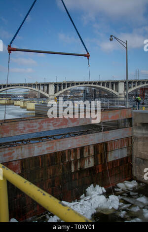 Schotte am oberen St. Anthony Falls Sperre entfernt - die letzte Hürde in $ 3 Millionen Upgrade: ein Unternehmer Besatzungen Aufzüge stahl Schotte auf der vorderen Seite des St. Anthony Falls Lock am 20. März eine heikle Manöver im Vorfeld der zu erwartenden hohen Flows, die sich aus der Schneedecke abgeschlossen im Mississippi Oberläufe schmelzen. Für fast zwei Wochen Mitarbeiter und Personal von der Wartung und Reparatur Abschnitt brachen die Dämme des Eis, das unterhalb der Schotte angesammelt hatte, um sicherzustellen, dass die Mitra Tore und tainter Gate funktionsfähig waren und die Schotten würden nicht während ihrer Ausbau mittels eines Cr-Stick Stockfoto