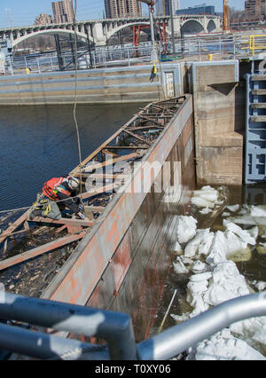 Schotte am oberen St. Anthony Falls Sperre entfernt - die letzte Hürde in $ 3 Millionen Upgrade: ein Unternehmer Besatzungen Aufzüge stahl Schotte auf der vorderen Seite des St. Anthony Falls Lock am 20. März eine heikle Manöver im Vorfeld der zu erwartenden hohen Flows, die sich aus der Schneedecke abgeschlossen im Mississippi Oberläufe schmelzen. Für fast zwei Wochen Mitarbeiter und Personal von der Wartung und Reparatur Abschnitt brachen die Dämme des Eis, das unterhalb der Schotte angesammelt hatte, um sicherzustellen, dass die Mitra Tore und tainter Gate funktionsfähig waren und die Schotten würden nicht während ihrer Ausbau mittels eines Cr-Stick Stockfoto