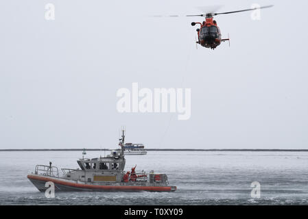 Ein Coast Guard Station Los Angeles-Long Beach 45-Fuß-Antwort Boat-Medium Crew führt eine hoist Demonstration mit einer Küstenwache Air Station San Francisco-Forward Operating Base Point Mugu MH-65 Dolphin helicopter Crew im Hafen von Los Angeles, 21. März 2019. Die Demonstration folgte dem 2019 Stand der Küstenwache Adresse von Adm geliefert. Karl Schultz, Coast Guard Kommandant. (U.S. Coast Guard Foto von Seaman Ryan Estrada/Freigegeben) Stockfoto