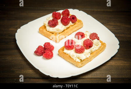 Süße Waffeln mit Sahne und frischen Himbeeren. Dessert Stockfoto