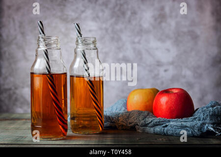 Auf dem Tisch sind Äpfel und frisch gepressten Saft in einer Glasflasche Stockfoto