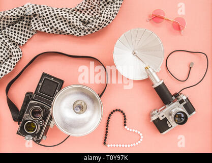 Vintage foto Kameras mit blinkt, auf rosa Leinwand Hintergrund. Stockfoto