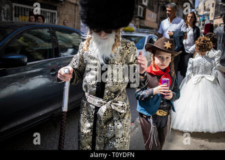 Jerusalem, Israel. 22 Mär, 2019. Ultra-orthodoxe Juden feiern Purim in der streng religiösen Mea Shearim Viertel von Jerusalem, Israel. Der Karneval - Wie holiday Purim gefeiert, mit Paraden und Kostüm Parteien die Befreiung des jüdischen Volkes aus einem Grundstück in der alten Persischen Reich zu vernichten vor 2.500 Jahren zu gedenken, wie sie im Buch Esther beschrieben. Credit: Ilia Yefimovich/dpa/Alamy leben Nachrichten Stockfoto