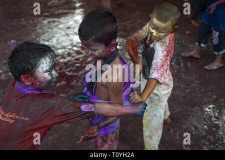 Narayanganj, Narayanganj Sadar, Bangladesch. 22 Mär, 2019. Kinder gesehen reißen einander Shirts während der Feier. Holi als das Fest der Farben bekannt ist eine alte hinduistische Frühlingsfest, die jetzt in vielen Ländern und Bangladesch gehört zu jenen gefeiert. Viele Menschen tanzen Programme arrangieren und spielen mit Farben, Pulver und Wasser zum Ausdruck zu bringen und ihr Glück mit anderen teilen. Credit: Ziaul Haque Oisharjh/SOPA Images/ZUMA Draht/Alamy leben Nachrichten Stockfoto