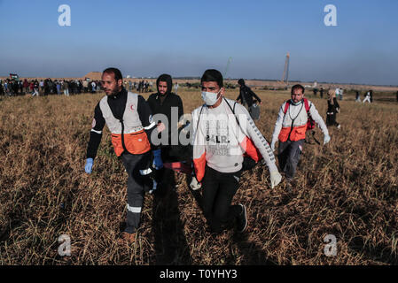 März 22, 2019 - Gaza, Palästina, Palästina - Ärzte gesehen, die eine verletzte Demonstrant während der zusammenstöße.. palästinensische Demonstranten Zusammentreffen mit israelischen Truppen nach dem Zelte protestieren, wo Palästinenser fordern das Recht, in ihre Heimat an der Grenze Israel-Gaza zurückzukehren, in Khan Younis im südlichen Gazastreifen. Zwei Palästinenser durch israelische Feuer während der Auseinandersetzungen getötet wurden, das Gesundheitsministerium in der Hamas-run-Enklave sagte. (Bild: © yousef Masoud/SOPA Bilder über ZUMA Draht) Stockfoto