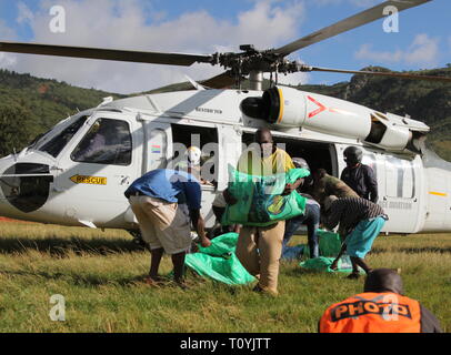 (190322) - CHIMANIMANI (Simbabwe), 22. März 2019 (Xinhua) - Arbeitnehmer gespendete Lebensmittel aus einem Hubschrauber in Chimanimani, Provinz Manicaland, Simbabwe, 22. März 2019 entladen. Simbabwes Präsident Emmerson Mnangagwa am Donnerstag hat zwei Tage der Trauer nach dem verheerenden Zyklon Idai die 139 Leute getötet hat, und eine Spur der Verwüstung in den östlichen und südlichen Teile des Landes links erklärt. Als Rettungs- und Suche weiter, Spenden von Hilfsgütern für die Opfer weiterhin von lokalen Personen, Firmen, regionale Regierungen und internationalen Hilfsorganisationen zu gießen Stockfoto