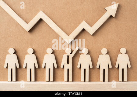 Business- und Designkonzept - Gruppe der Holz- Geschäftsmann Symbol mit Pfeil auf Kraftpapier. Es ist börse Finanzkonzept Stockfoto