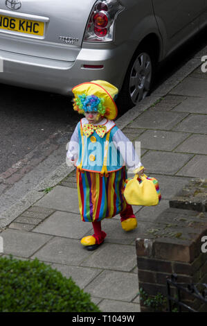 Chassidischen Jungen in clown Fancy Dress mit Regenbogen Haaren und Kleidung feiert die jüdische Feiertag Purim in Stamford Hill, London Stockfoto