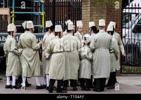 Chassidischen jungen junge Männer in Fancy Dress in Stamford Hill tanzen und singen und sammeln für wohltätige Zwecke auf der jüdische Feiertag Purim Stockfoto