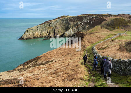 Wanderer Wandern auf dem Coast Path nähern Porth Llanlleiana von Cemaes, Isle of Anglesey, Wales, Großbritannien, Großbritannien Stockfoto