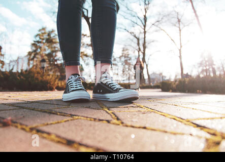 Schwarze Sneakers auf die Beine einer Frau Fuß in den Park Stockfoto