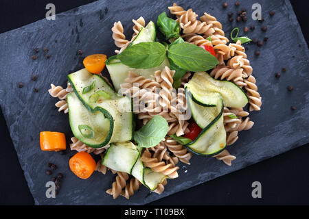 Leckere Pasta Salat mit grünem Salat, Tomaten und gebratenem Huhn. Stockfoto