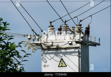 Power System mit elektrischen Bedienfeld mit Warnung Stromschlaggefahr Zeichen'' auf dem Hintergrund der blauen Himmel close-up Stockfoto