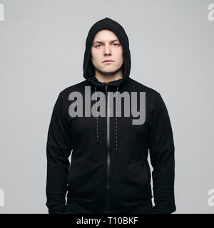 Schöner Mann in Schwarz hoodie bei Kamera posieren. Stockfoto