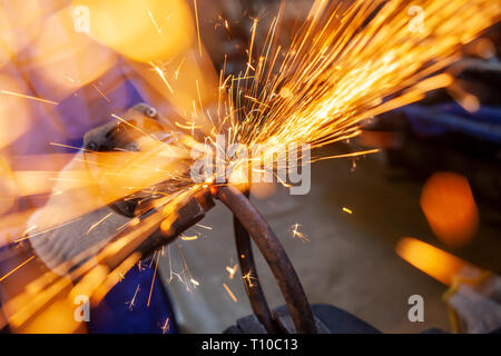 Hell orange und gelb Funken auf schwarzem Hintergrund. Ein Strom von Helle Funken von Schneiden von Metall Stockfoto